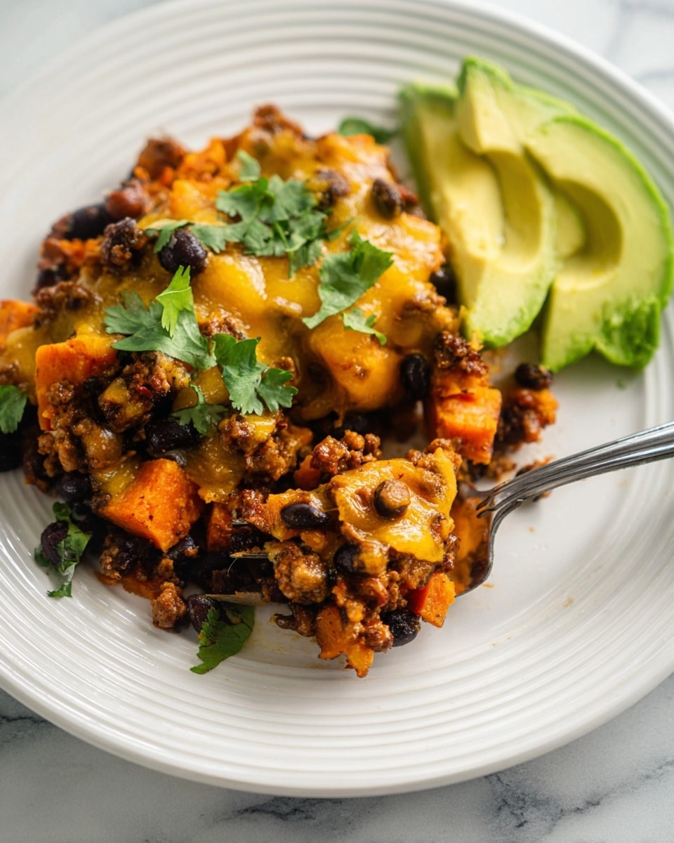 The dish shows a close-up of a cooked mix with three main layers: the base layer has soft pieces of orange sweet potato mixed with cooked, crumbled brown ground beef and black beans spread evenly; the middle layer is melted golden-yellow cheese melted over the mix, adding a creamy texture; on top, there are fresh green cilantro leaves scattered for color contrast, and two slices of bright green avocado are placed on the side on a white plate with a ridged edge, all set on a white marbled texture. A silver fork holds a bite of the mix with melted cheese stretching slightly. Photo taken with an iphone --ar 4:5 --v 7