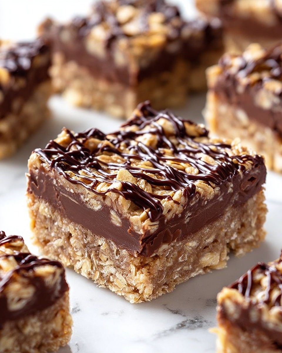 A close-up of a square dessert bar showing three distinct layers: the bottom layer is a dense, light brown oat mixture with a crumbly texture; the middle layer is a thick, smooth chocolate filling in a darker brown shade; the top layer is a more loose oat mixture with visible oat flakes, drizzled with shiny dark chocolate in thin zigzag lines. The bar is placed on a white marbled surface with several similar bars blurred in the background. photo taken with an iphone --ar 4:5 --v 7