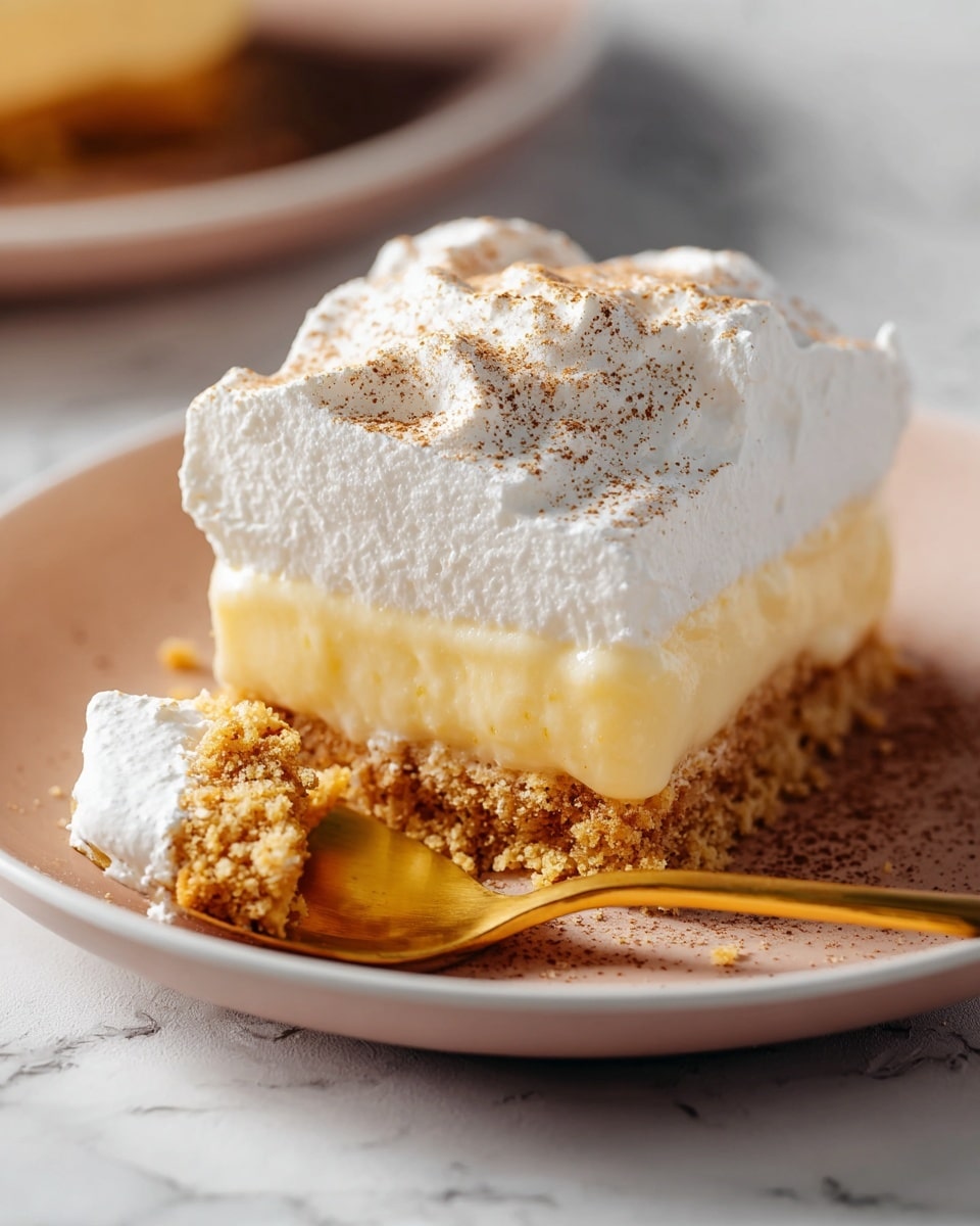 A close-up image of a three-layer dessert slice on a white plate sitting on a white marbled surface. The bottom layer is a crumbly golden brown crust, the middle layer is a smooth, pale yellow custard, and the top layer is a thick, fluffy white cream generously dusted with light brown powder. A gold spoon resting on the plate holds a bite-size piece capturing all three layers, showing the textures clearly. The lighting highlights the creamy and crumbly contrasts, creating a soft and inviting look. Photo taken with an iphone --ar 4:5 --v 7